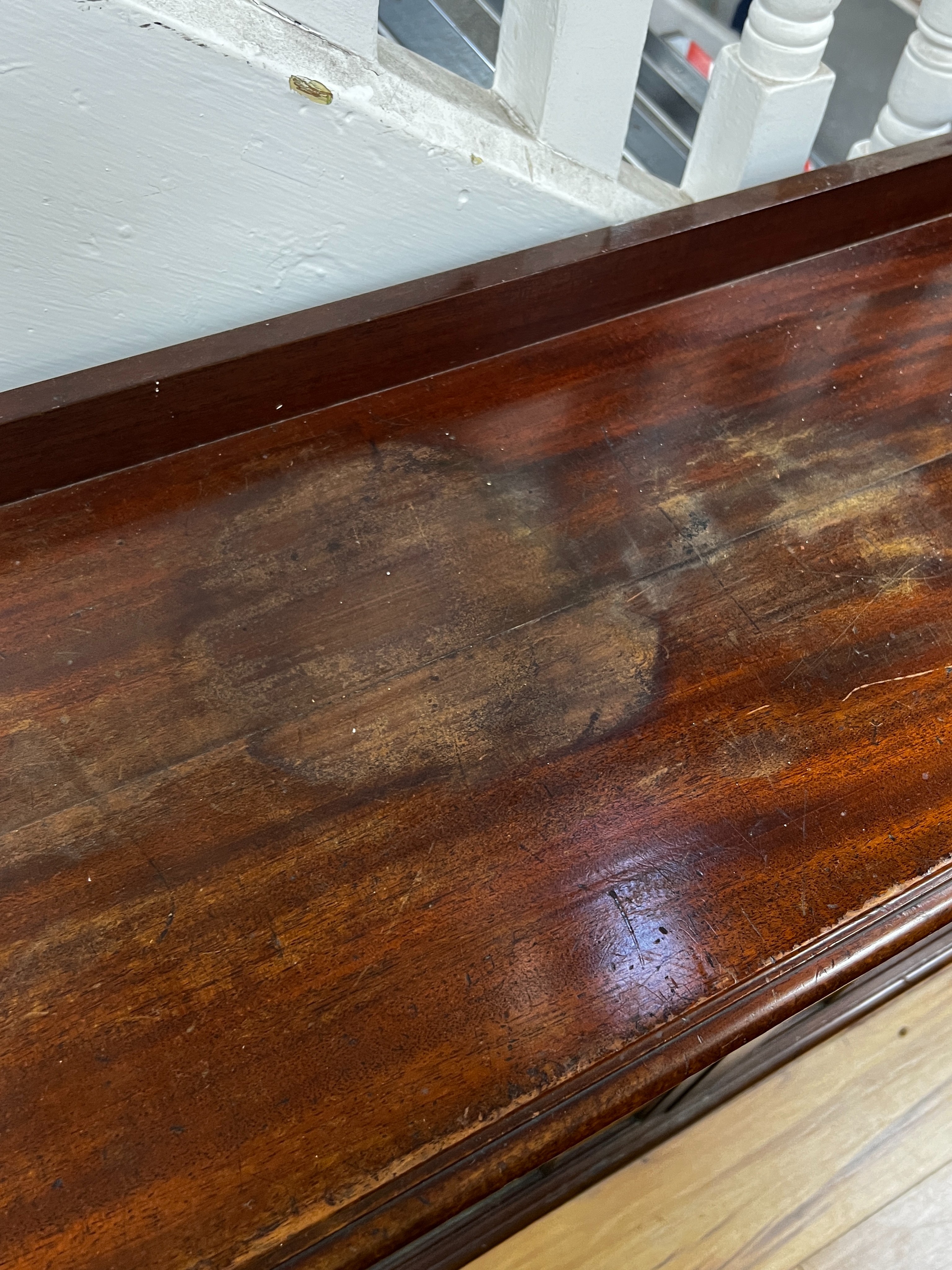 An Edwardian glazed mahogany dwarf bookcase, enclosed by six astragal glazed sliding doors, width 290cm, depth 34cm, height 94cm